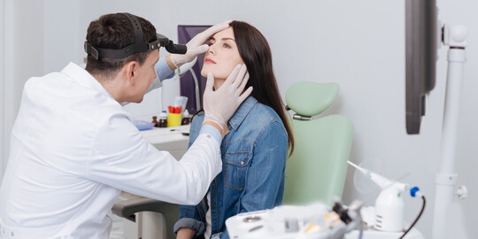 Arzt untersucht Frau zur Vorbereitung auf eine Nasenscheidewand OP, auch Septumplastik genannt