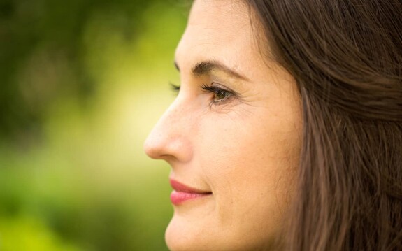 Nahansicht Frau mit brünetten Haaren von der Seite mit Fokus auf die Nase.